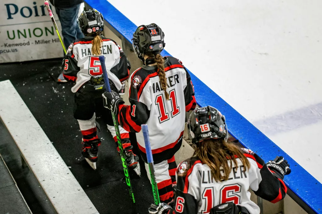 Hockey players lined up on the bench for their next shift.